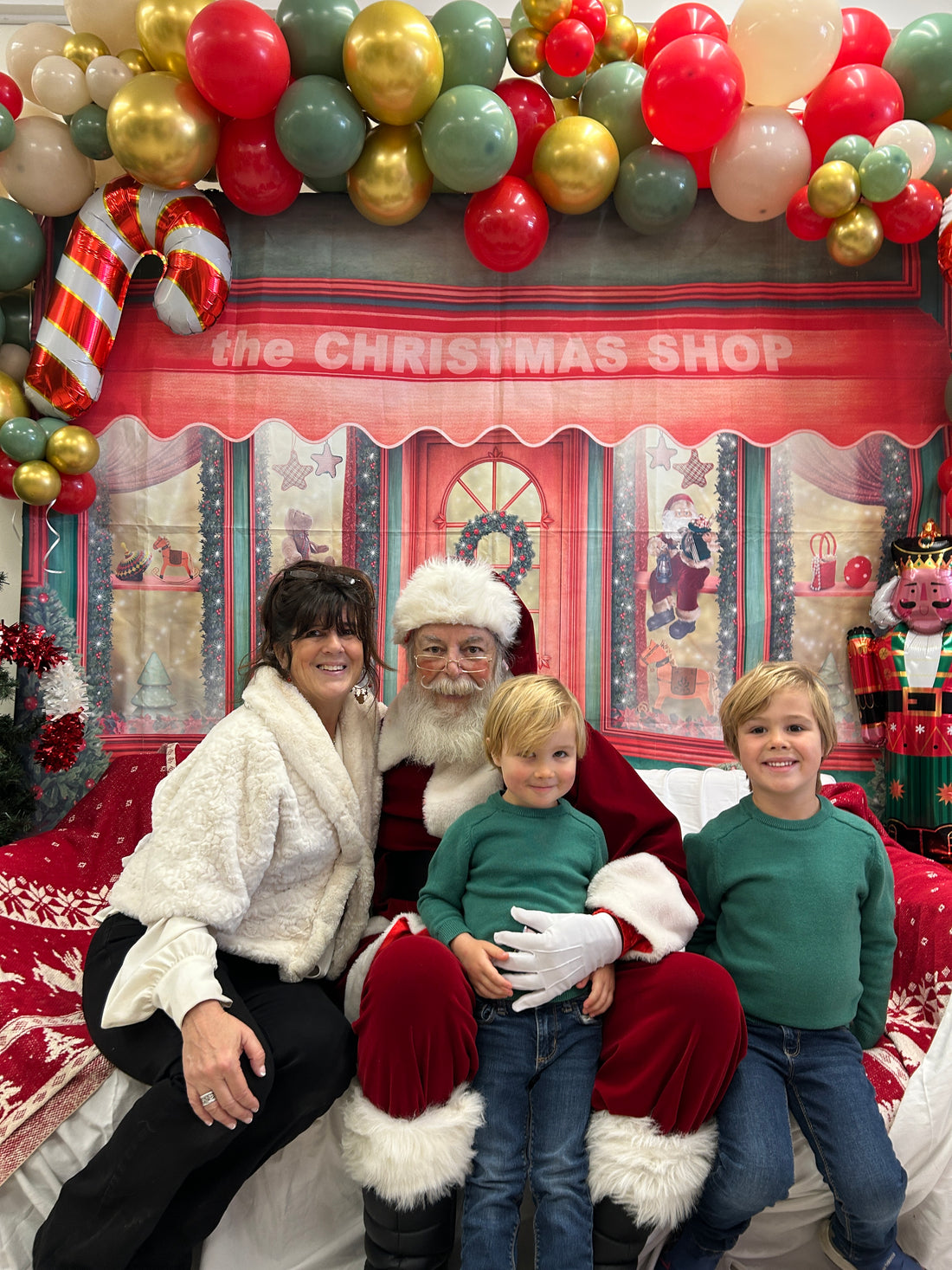 Our small business owner, Sally Frey poses with Santa Claus and her two excited grandsons.