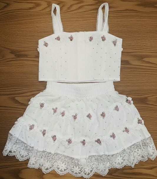 White lace dress with floral embroidery on a wooden surface