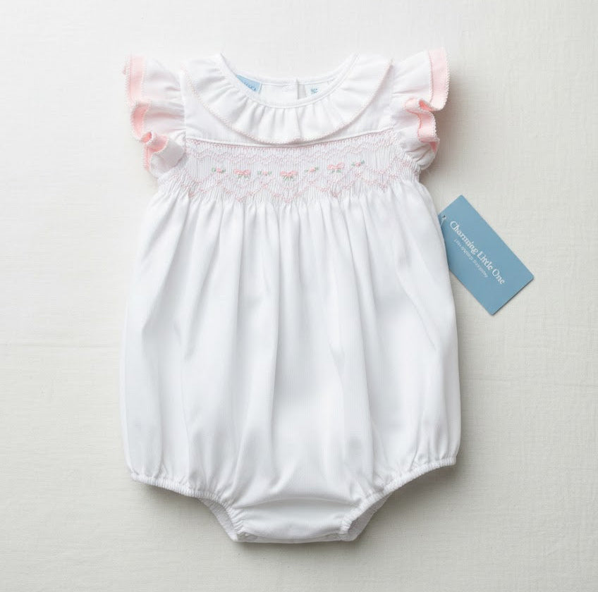 White baby romper with pink trim on a light gray background