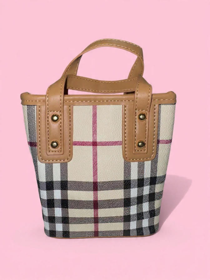 Checkered bag with brown handle and trim on a pink background